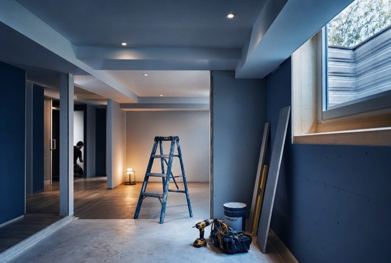 A basement renovation in progress with fresh drywall and pot lights